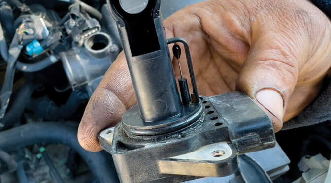 MAF sensor being held above an engine